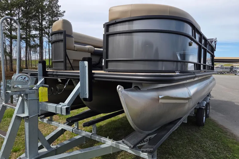 Slide: The Image of 2024 Starcraft EXS 1 pontoon boat on trailer, parked outdoors. - 6