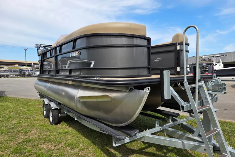 Slide: The Image of 2024 Starcraft EXS 1 pontoon boat on trailer, parked outdoors under blue sky. - 7