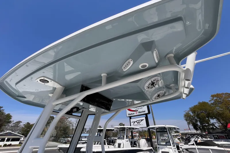 Slide: The Image of 2025 Tidewater 2500 Carolina Bay boat with T-top and speakers, under clear blue sky. - 13