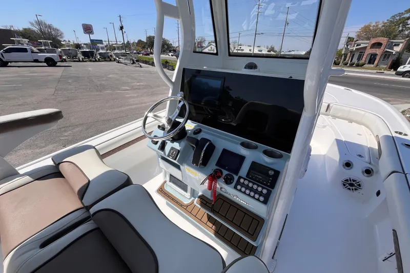 Slide: The Image of 2025 Tidewater 2500 Carolina Bay boat cockpit with steering wheel and control panel. - 7