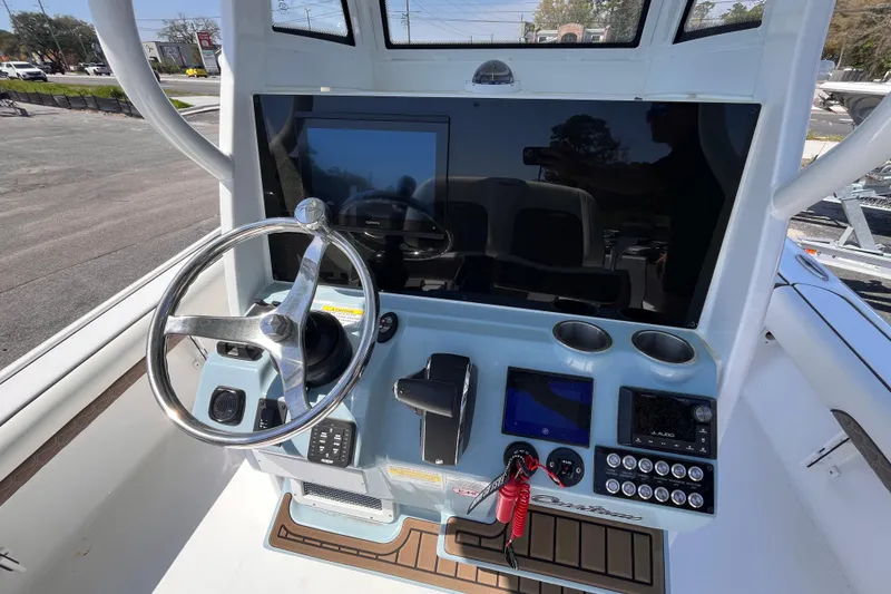 Slide: The Image of 2025 Tidewater 2500 Carolina Bay boat dashboard with steering wheel and electronic controls. - 8