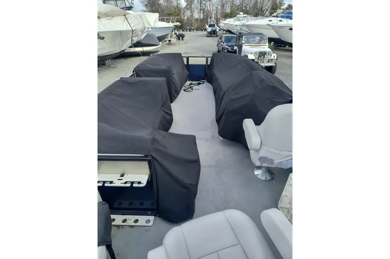 Slide: The Image of 2018 Crest I Fish 220 C4 pontoon boat with covered seating, parked in a marina. - 5