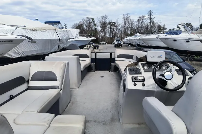 Slide: The Image of 2018 Crest I Fish 220 C4 pontoon boat with Garmin navigation, docked among other boats. - 6