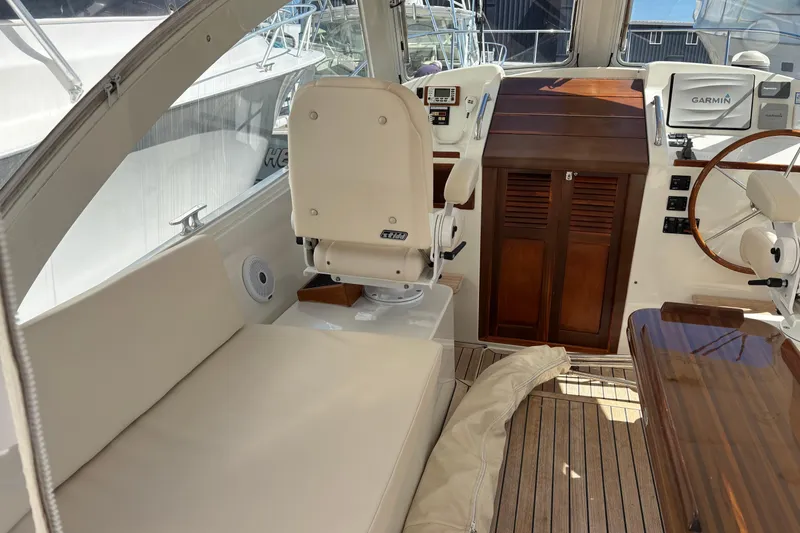 Slide: The Image of 2006 MJM 34z Express HT boat interior with helm, seating, and Garmin navigation system. - 13