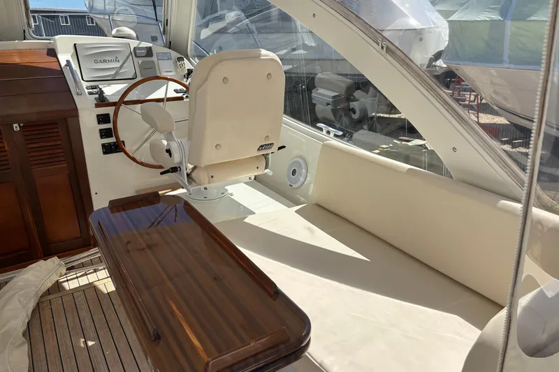 Slide: The Image of 2006 MJM 34z Express HT yacht interior with helm, seating, and wooden table. - 14