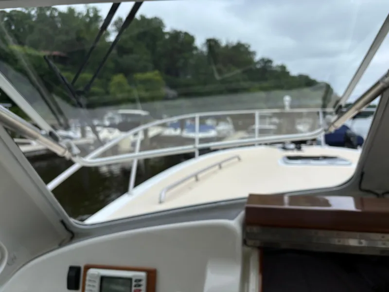 Slide: The Image of 2006 MJM 34z Express HT boat interior view with windshield and docked boats. - 19