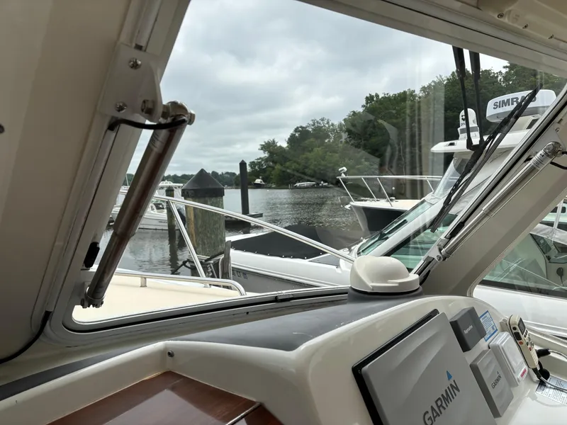 Slide: The Image of 2006 MJM 34z Express HT boat interior with Garmin navigation, docked by a serene waterfront. - 20