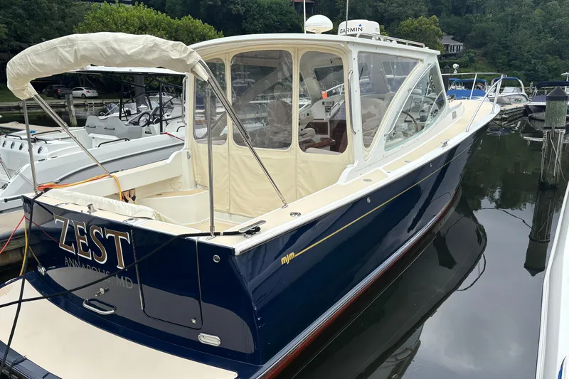 Slide: The Image of 2006 MJM 34z Express HT boat docked, featuring sleek design and elegant navy blue exterior. - 3