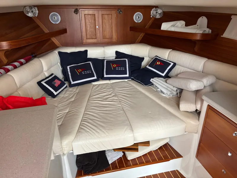 Slide: The Image of 2006 MJM 34z Express HT cabin with white leather seating and nautical-themed cushions. - 30