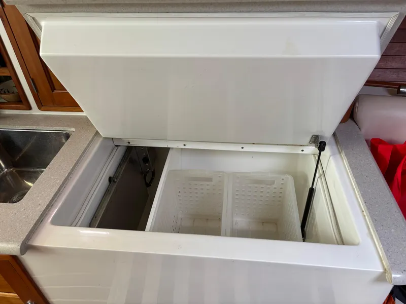 Slide: The Image of Open storage compartment on 2006 MJM 34z Express HT boat, featuring a white interior. - 32