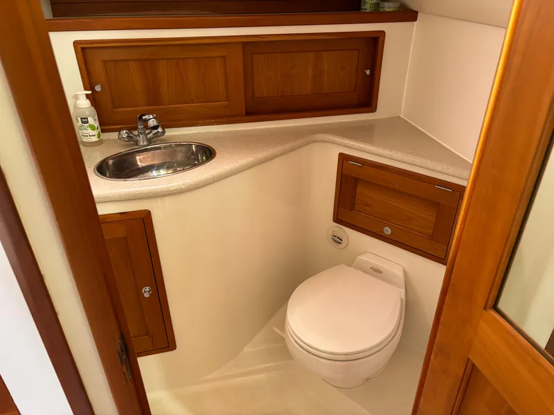 Slide: The Image of 2006 MJM 34z Express HT boat bathroom with wooden cabinets and compact design. - 34