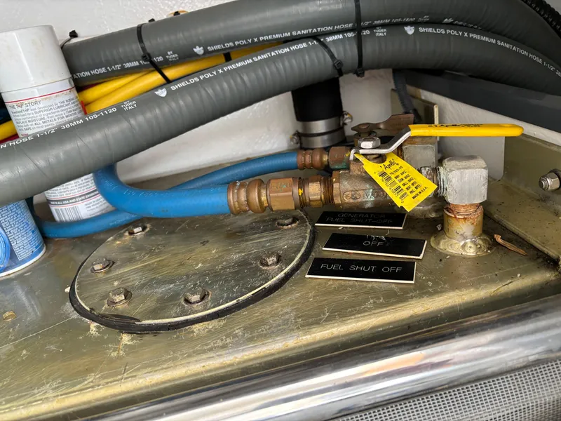 Slide: The Image of Fuel shut-off valve on a 2006 MJM 34z Express HT boat, with hoses and labels. - 45