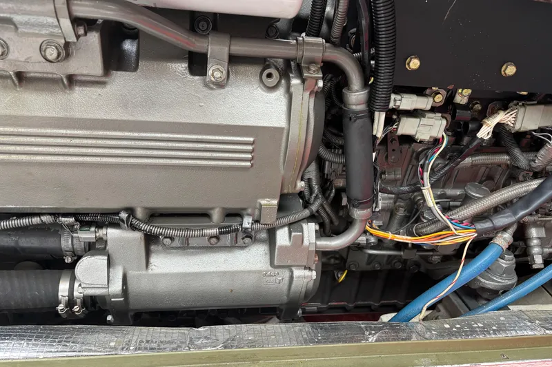 Slide: The Image of Engine components of a 2006 MJM 34z Express HT boat, featuring wiring and hoses. - 51