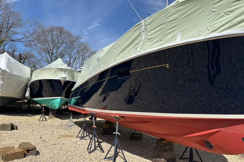 Slide: The Image of 2006 MJM 34z Express HT boat stored on stands, covered, outdoors. - 6