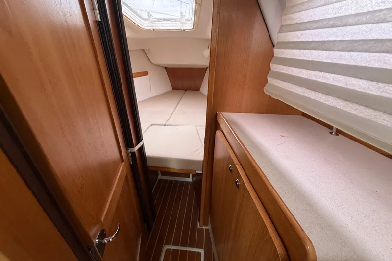 Slide: The Image of Interior cabin of a 2007 Catalina 309 sailboat with wooden finishes and cozy sleeping area. - 10
