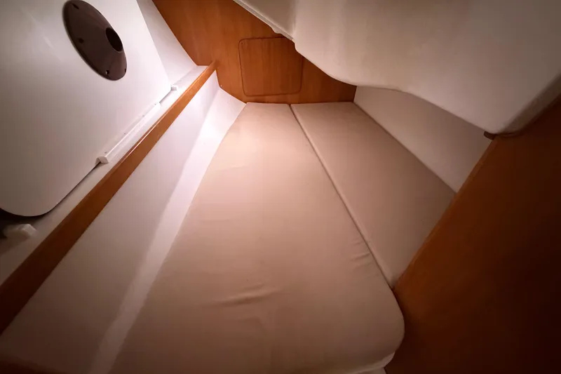 Slide: The Image of Interior cabin of a 2007 Catalina 309 sailboat with beige cushions and wooden accents. - 16