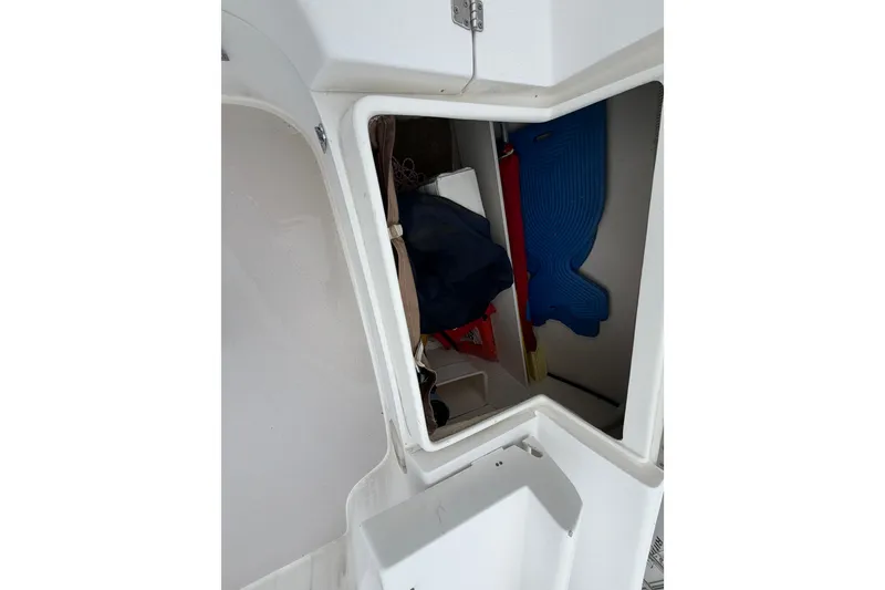Slide: The Image of Open storage compartment on a 2007 Catalina 309 sailboat, showing interior items. - 19