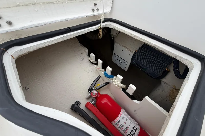 Slide: The Image of Open storage compartment on a 2007 Catalina 309 sailboat with fire extinguisher and equipment. - 21