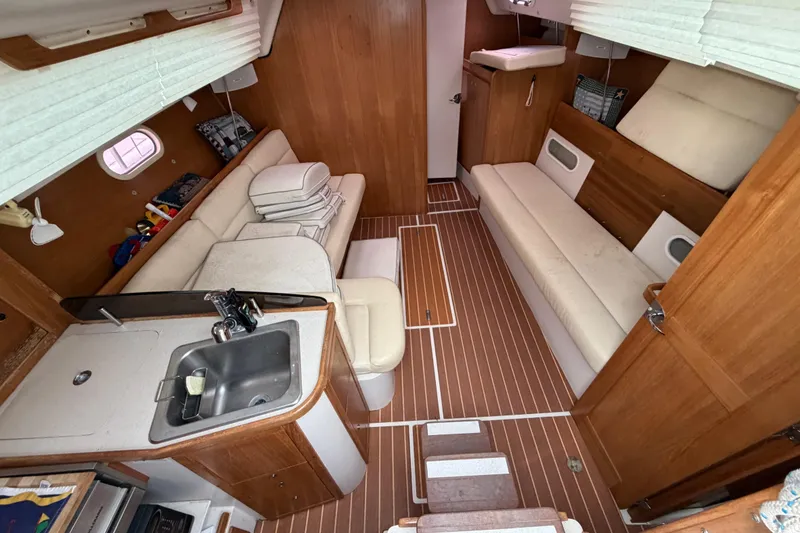 Slide: The Image of Interior of a 2007 Catalina 309 sailboat with wood paneling and compact kitchen area. - 26