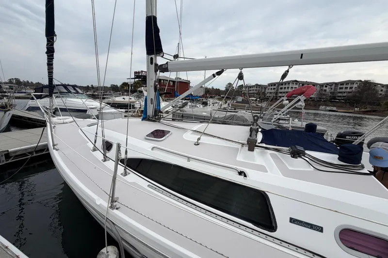 Slide: The Image of Catalina 309 sailboat from 2007 docked at a marina, surrounded by other boats. - 4