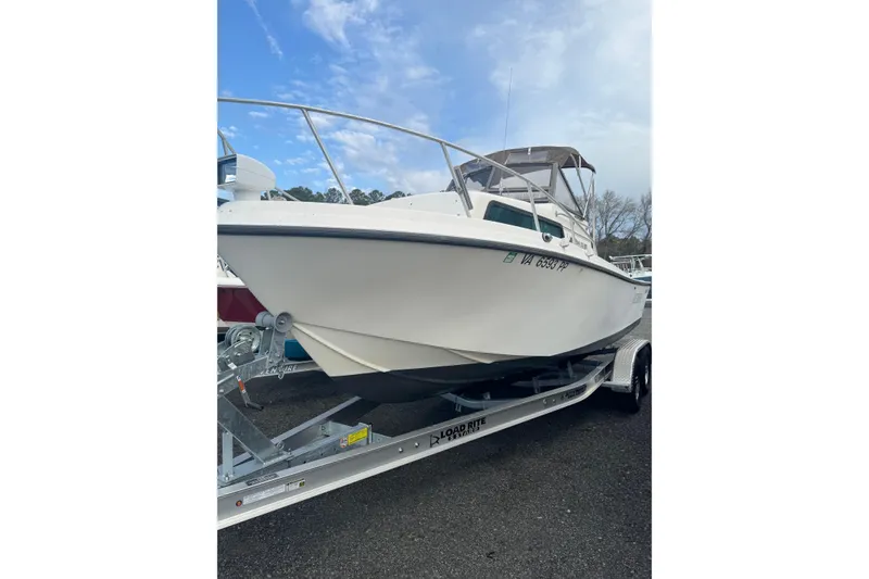 The Image of 1987 Mako 230 Walk Around boat on trailer under blue sky. - 0