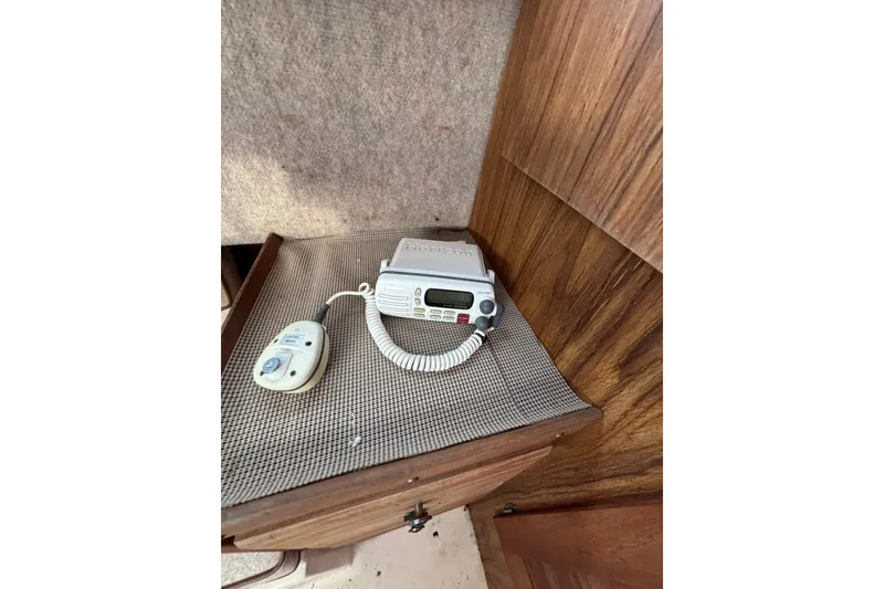 Slide: The Image of Marine radio and control panel inside a 1987 Mako 230 Walk Around boat cabin. - 11