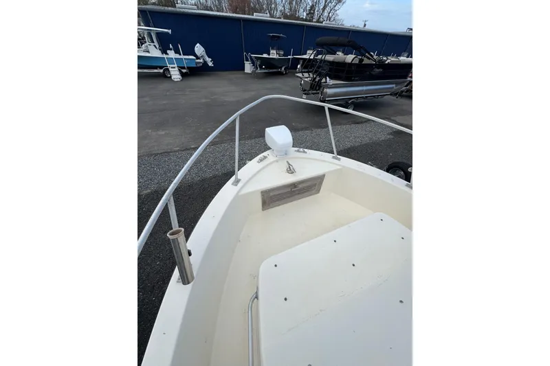 Slide: The Image of 1987 Mako 230 Walk Around boat bow view in a marina setting. - 14
