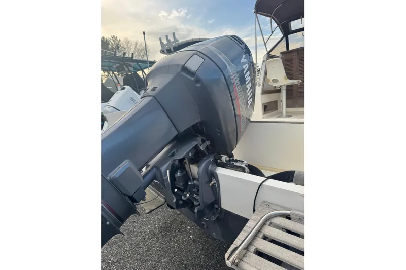 Slide: The Image of 1987 Mako 230 Walk Around boat with Yamaha outboard motor, docked outdoors. - 18