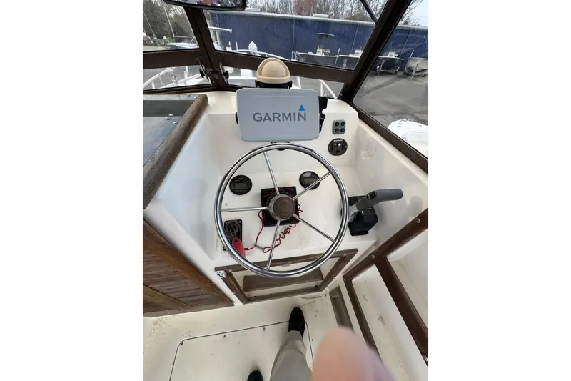 Slide: The Image of 1987 Mako 230 Walk Around boat helm with Garmin navigation system. - 6