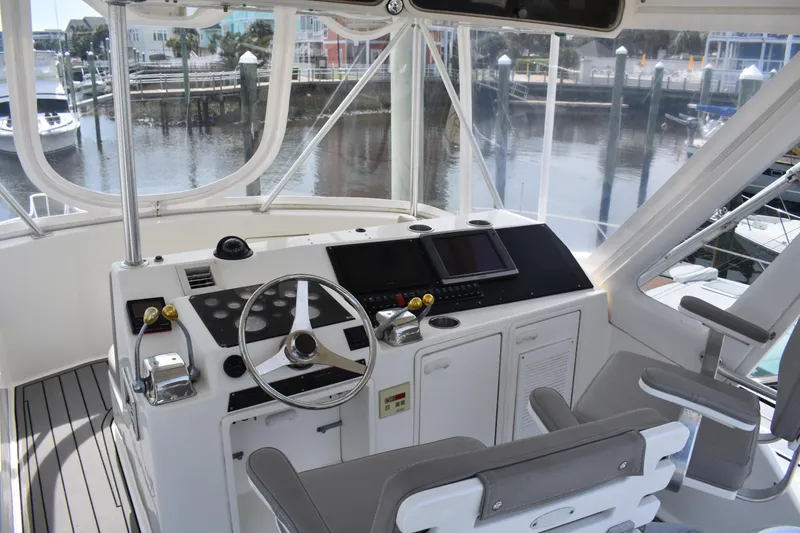 Slide: The Image of Helm of 1998 Ocean Yachts 40 Super Sport with modern controls and marina view. - 12