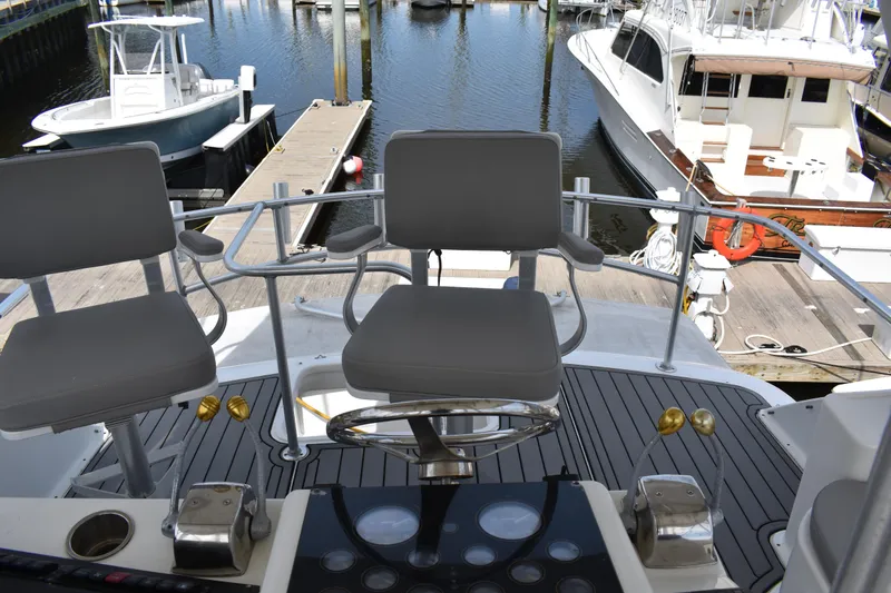 Slide: The Image of 1998 Ocean Yachts 40 Super Sport helm with chairs and marina view. - 16