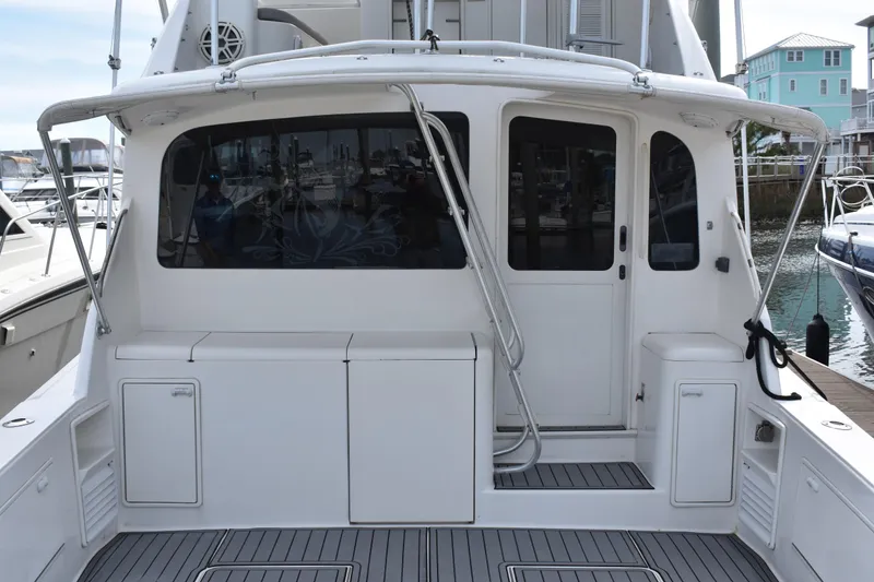 Slide: The Image of 1998 Ocean Yachts 40 Super Sport boat docked, featuring a spacious rear deck and sleek design. - 17