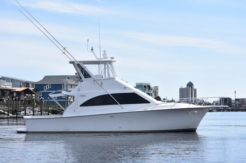Slide: The Image of 1998 Ocean Yachts 40 Super Sport boat docked in a marina, clear sky background. - 2