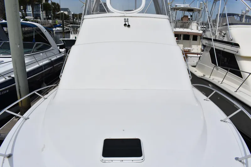 Slide: The Image of 1998 Ocean Yachts 40 Super Sport docked at marina, showcasing sleek design and spacious deck. - 24