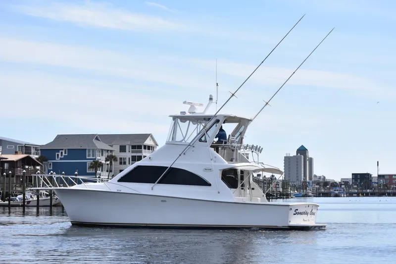 Slide: The Image of 1998 Ocean Yachts 40 Super Sport cruising in a marina with cityscape background. - 3
