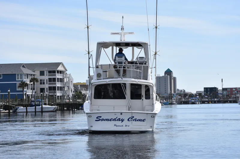 Slide: The Image of 1998 Ocean Yachts 40 Super Sport cruising in a marina with waterfront buildings. - 4