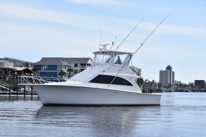 Slide: The Image of 1998 Ocean Yachts 40 Super Sport cruising near waterfront homes and city skyline. - 6