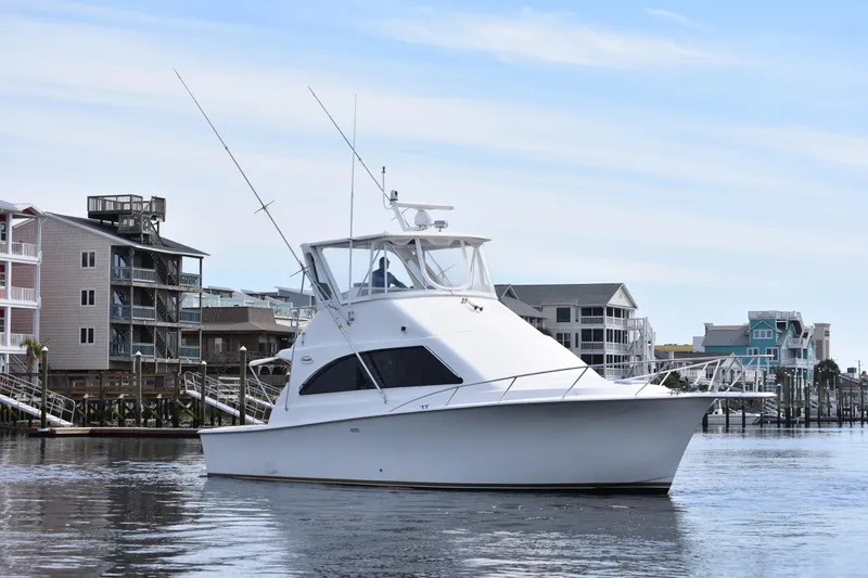 Slide: The Image of 1998 Ocean Yachts 40 Super Sport boat docked near waterfront homes. - 7