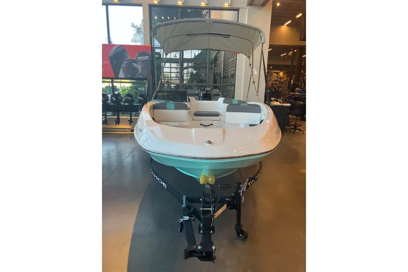 Slide: The Image of 2026 Tahoe T16 boat displayed indoors with canopy and trailer. - 1