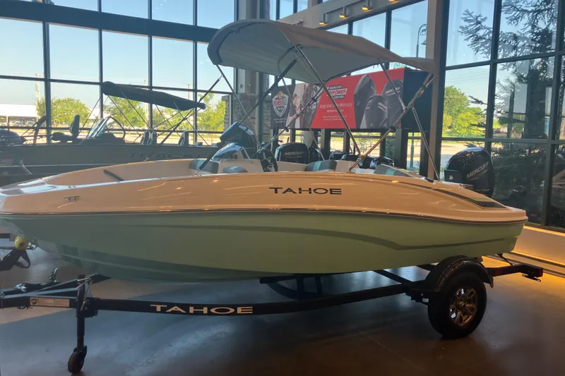 Slide: The Image of 2026 Tahoe T16 boat displayed indoors with canopy and trailer. - 11
