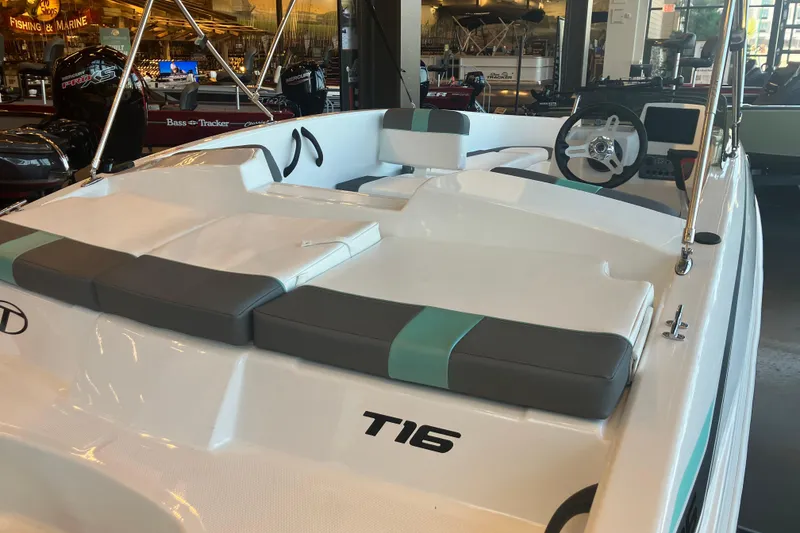 Slide: The Image of 2026 Tahoe T16 boat interior with modern seating and steering wheel in showroom. - 2