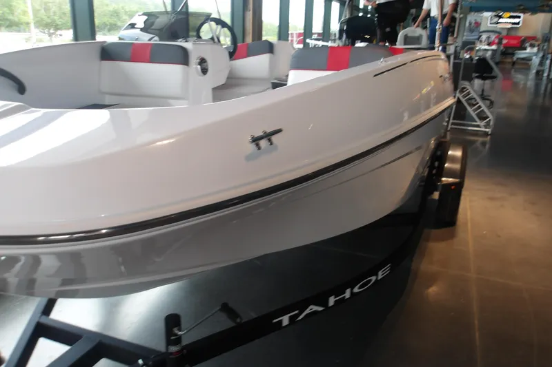 Slide: The Image of 2026 Tahoe T16 boat on display in showroom, featuring sleek white design and modern interior. - 10
