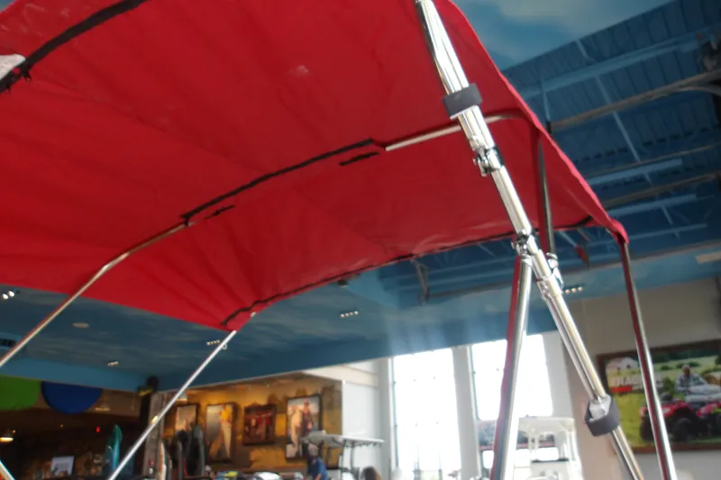 Slide: The Image of Red canopy on a 2026 Tahoe T16 boat displayed indoors. - 6
