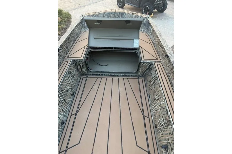 Slide: The Image of 2026 Tracker Grizzly 1650 T Prairie Wings Edition boat interior with open storage compartment. - 6