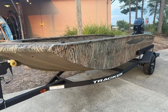 The Image of 2026 Tracker Grizzly 1650 T Prairie Wings Edition boat with camouflage design on a trailer. - 0