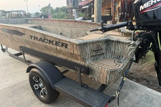 Slide: The Image of 2026 Tracker Grizzly 1650 T Prairie Wings Edition boat with camouflage design on a trailer. - 2