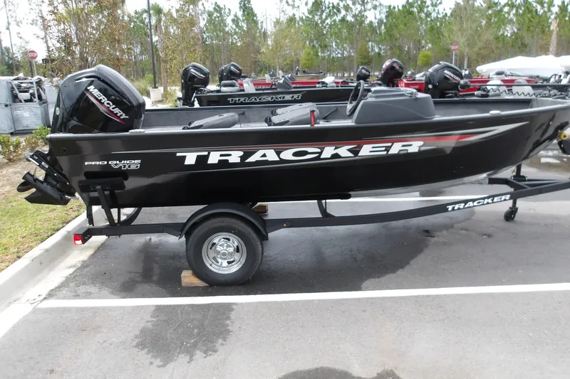 The Image of 2026 Tracker Pro Guide V-16 SC boat on trailer, parked outdoors. - 1