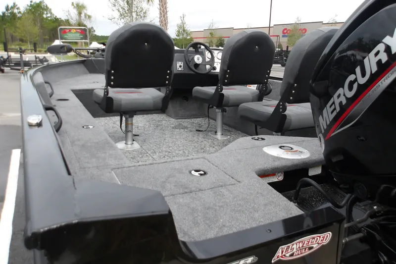 Slide: The Image of 2026 Tracker Pro Guide V-16 SC boat interior with Mercury engine, featuring seating and carpeted deck. - 14