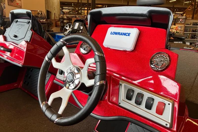 Slide: The Image of Red Nitro Z18 2026 boat dashboard with steering wheel and Lowrance display. - 1