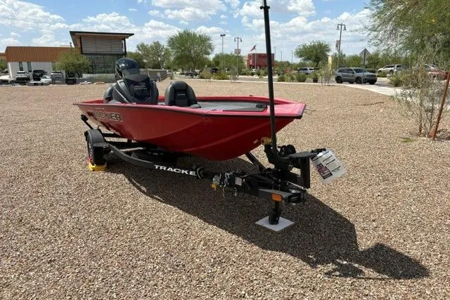 The Image of Red 2026 Tracker Pro Team 175 boat on trailer in gravel lot under sunny sky. - 0